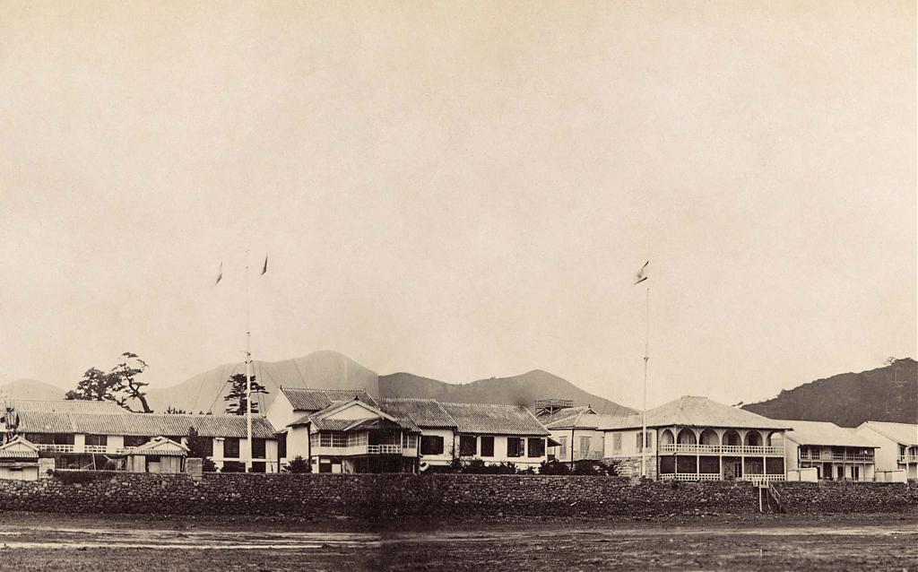 1863年ごろの出島の領事館(左の旗竿下の建物)。